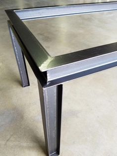 a metal table sitting on top of a cement floor