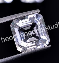 an emerald cut diamond sitting on top of a black surface