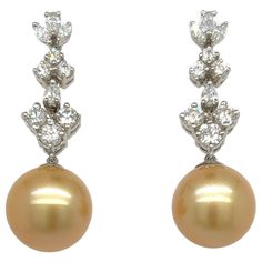 Glamorous dangling earrings. High luster, golden South Sea match pearls, accented with 2.33 carats high brilliance round diamonds. Handcrafted dangling earrings assembles in 18 karats white gold with post and butterfly post. South Sea Pearl: 13mm, high luste, golden tone (AAA quality) Diamond: 2.33 carats round brilliant cut Color: F-G Clarity: VS1-I1 Dimensions: 40mm x 10mm 3mm (approx) Multicolor Pearl Drop Earrings, Luxury Yellow Pearl Drop Jewelry, Yellow Gold Pearl Drop Earrings In Mother Of Pearl, Luxury Exquisite Pear-shaped Pearl Earrings, Luxury Gold-tone Pearl Drop Earrings, South Sea Pearls Earrings, Golden South Sea Pearls, Sea Pearl, South Seas