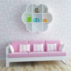 a pink and white couch sitting in front of a book shelf