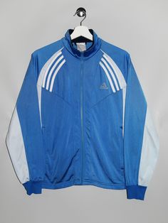 "Vintage Adidas Track Jacket  - Size tag: Please always check measurements before buying. Tag is faded, Fits Women's L - Measurements (laying flat): Pit to Pit: 21\" Length: 25\" Pit to Cuff: 20\" -Wear: /Please see images for details/ Overall in good vintage condition. Zip pull is missing -Flaws: / serious wear, tears, holes, marks or stains/ Please see images for details. None. - Fabric: 100% Polyester  *All of our items are preloved pieces so some signs of natural wear and age are to be expected. Please look through the photos carefully to check if the condition is to your satisfaction. *All efforts are made to show any defects however small imperfections may be missed. *We try to describe the sizes as accurately as possible, but please keep in mind that sizes nowadays can differ to siz Luxury Blue Winter Track Jacket, Cheap Blue Track Jacket For Sports, Cheap Blue Adidas Activewear, Sportswear Long Sleeve Track Jacket For College, Long Sleeve Sportswear Track Jacket For College, Vintage Long Sleeve Sports Outerwear, Blue College Track Jacket With Pockets, Three Stripes Sportswear Outerwear For Training, Sportswear Outerwear With Three Stripes For Training