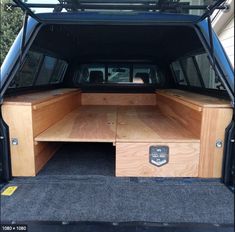 the back end of a blue van with its trunk open and drawers opened in front of it