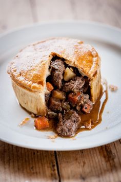 a piece of meat and vegetable pie on a white plate