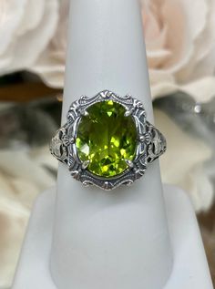 "Natural Green Peridot Ring Description Beauty Design#229 MADE To ORDER This is a brand new stunning Art Nouveau/Victorian reproduction sterling silver filigree ring. The oval-cut high-quality natural peridot is 12mm by 10mm (just shy of 3/8\" inch) in dimension... The ring is 5/8th of an inch (16.5mm) NS (long) on the finger. The ring and gem sit 7mm off the finger. The inside of the band is marked 925 for sterling. Notice the beautiful filigree swirl like the craftsmanship of the silver settin Oval May Birthstone Gemstone With Center Stone, Heirloom Oval Green Ring, Oval Hallmarked Peridot Jewelry, Green Emerald Ring With Intricate Design, Green Oval Ring With Large Stone, Oval Green Ring With Large Stone, Hallmarked Oval Peridot Jewelry, Green Oval Emerald Ring With Intricate Design, Oval Peridot Ring In White Gold