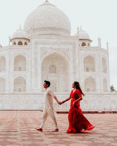 a man and woman holding hands in front of the tajwa mosque, india