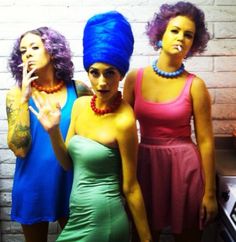 three women dressed in colorful clothing posing for the camera with their fingers on their lips