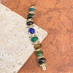 Estate/ vintage 14KT yellow gold oval, genuine, green onyx, blue onyx, black onyx, jasper, agate, scarab bracelet. Bullet spacer details between the gemstone links. Amazing, carved, scarab design on some of the pieces, others plain. Length: 8” Weight: 34.36 grams Band width: 12.5mm at widest Hallmarked and stamped 14K Push In clasp Good estate condition Some repaired work has been done to this piece Vintage Yellow Gold Cabochon Bracelets, Vintage Onyx Oval Cabochon Jewelry, Yellow Oval Cabochon Gemstone Jewelry, Vintage Oval Multi-stone Bracelets, Scarab Bracelet Vintage, Scarab Bracelet, Blue Onyx, Green Onyx, Black Onyx