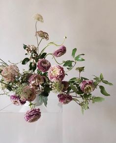 a vase filled with lots of flowers on top of a table