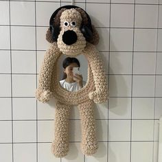 a woman taking a selfie in front of a crocheted dog mirror