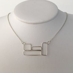 "This necklace is made of sterling silver and features a cluster of four rectangular boxes in the center of the chain. The rectangular boxes are 1 1/2\" wide and 3/4\" tall. The chain is 1.5 mm cable chain and it has a lobster claw clasp. The chain has 2 places where it can be clasped, one at 17 1/4\", the other at 18 1/4\". The necklace will be shipped in a decorative cardboard jewelry box filled with an anti tarnish cotton. Sterling silver is a metal that can tarnish, storing it in the box in Cardboard Jewelry, Small Gold Hoops, Cardboard Jewelry Boxes, Hammered Hoop Earrings, Square Necklace, Heart Choker, Cluster Necklace, Bib Necklaces, Geometric Necklace