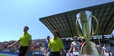 two tennis players are walking towards the trophy on the court while spectators watch from the stands