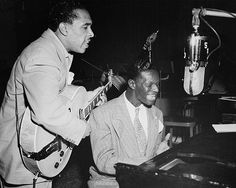 two men are playing music together in front of a microphone and an old record player