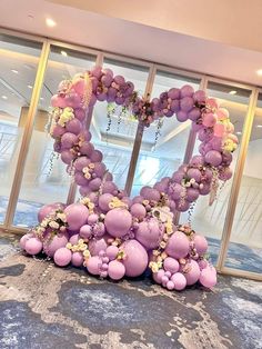 a heart shaped balloon decoration in front of a window