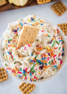 a bowl filled with rice and sprinkles next to crackers on the side