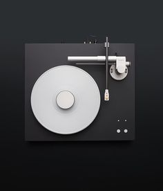 an overhead view of a white plate and toilet paper dispenser on a black surface