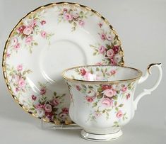 an antique tea cup and saucer set with pink flowers on the rim, gold trimmings