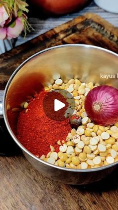 a metal bowl filled with food on top of a wooden table