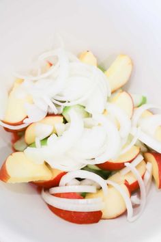 an apple and onion salad in a white bowl