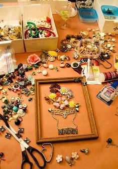 an assortment of jewelry is displayed on a table with scissors and other items around it