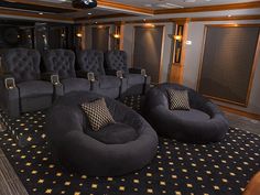 an empty theater room with black chairs and gold stars on the carpeted flooring