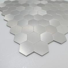 a silver hexagonal tile pattern on a white table with no one in it