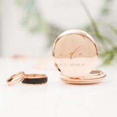 two wedding rings sitting on top of each other next to a round rose gold ring