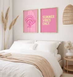 two posters on the wall above a bed in a room with white sheets and pillows