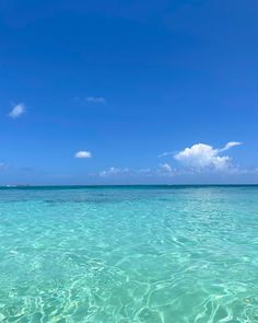 clear blue water with small white clouds in the sky