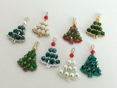 six christmas tree ornaments are arranged on a white surface