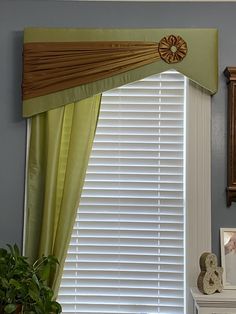 the window is decorated with green and brown drapes, along with an antique clock