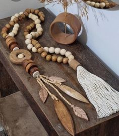 a wooden table topped with beads and tassels