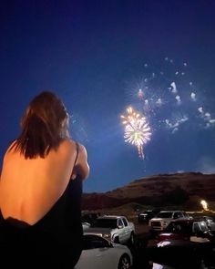 a woman looking at fireworks in the sky