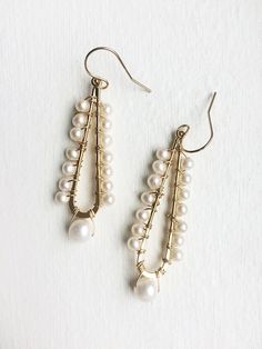 A celebration of pearls in a modern style. A larger pearl dangles from the bottom while smaller pearls line the long teardrop. + Pearls. 14K Gold Filled Ear Wire. 14K Gold Plated Teardrop. + Earrings measure 2.5 inches (6.3 cm) in length. + Earrings take 1 business day to make. + Your jewelry will come in a jewelry box, tied with a ribbon. ➤➤ Have a question about this product, reach out to me here ➙ https://www.etsy.com/conversations/new?with_id=9057464&referring_id=5772224&referring_ty Pearl White Teardrop Pearl Chain Earrings, Teardrop Pearl Chain Earrings In Pearl White, Teardrop Pearl White Earrings With Pearl Chain, Elegant Pearl Chandelier Earrings With Dangling Beads, Pearl White Chandelier Earrings With Pearl Drop For Anniversary, Pearl White Pearl Drop Chandelier Earrings For Anniversary, Classic White Pearl Drop Chandelier Earrings, Pearl White Chandelier Earrings For Anniversary, Party Teardrop Pearl Earrings