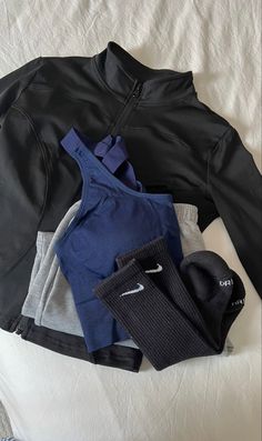 there is a jacket, leggings and other items on the bed