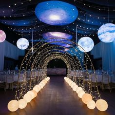 an image of a wedding venue setting with lights and moon decorations on the ceiling at night