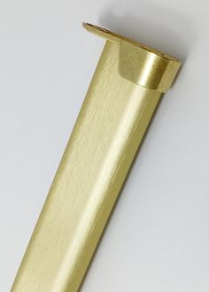 a close up of a gold colored metal object on a white surface with no background