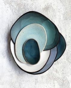 three blue and white plates stacked on top of each other in the shape of circles