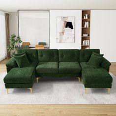 a living room with a large green sectional couch and white rug on the hardwood floor