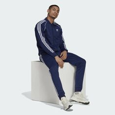 Slim fit Ribbed collar Elastic waist with drawcord 60% recycled polyester, 40% cotton interlock Heavyweight fabric Classic adidas track suit Front zip pockets Ribbed cuffs and hem Tapered track pants Imported Product color: Night Sky / White Product code: H06710/H06714 Adidas Sporty Tracksuit For Sports, Adidas Activewear With Ribbed Cuffs, Blue Tracksuit With Ribbed Cuffs, Winter Athleisure Tracksuit With Elastic Cuffs, Athleisure Tracksuit With Elastic Cuffs For Winter, Long Sleeve Tracksuit With Ribbed Cuffs For Jogging, Adidas Sportswear Tracksuit, Adidas Long Sleeve Tracksuit, Adidas Long Sleeve Tracksuit Sportswear