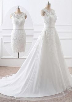 a white wedding dress on display in front of a wall with two mannequins