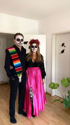 a man and woman in skeleton makeup standing next to each other on a wooden floor