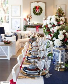 a table set for christmas dinner with blue and white decor