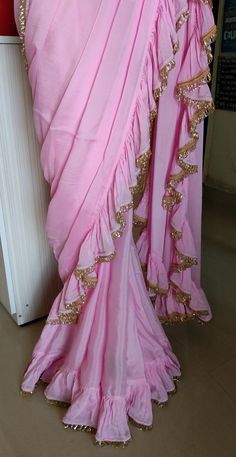 Color : Pink Fabric - Chinon This Ruffled Saree has beautiful Crystal Scallop trim at the hemline. Length of Saree 48 inches. Blouse : Pink Emroidered Net with Silk Lining The blouse and underskirt/petticoat will be stitched as per the measurements provided IF YOU WISH TO PURCHASE THIS WE CAN SEND A VIDEO ON YOUR WHATSAPP NUMBER FOR BETTER UNDERSTANDING OF THE SAREE Fabric Care : Dry Clean Only Disclaimer: The actual color of the product might slightly differ from the image due to photographic l Burgundy Quinceanera, Burgundy Quinceanera Dresses, Ruffled Saree, Bridesmaid Saree, Ruffle Saree, Scallop Trim, Saree Fabric, Whatsapp Number, Designer Saree