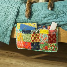 a dog laying on top of a bed next to a blanket and pillow with books