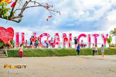 people standing in front of a large sign that says vulcanity on the side of a beach