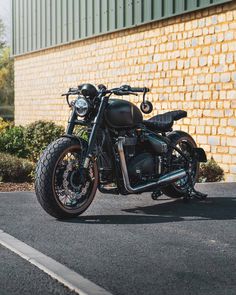 a black motorcycle parked in front of a brick building