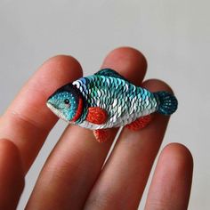 a small toy fish sitting on top of someone's hand