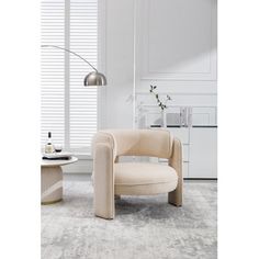 a living room with white walls and an oval chair in front of a window, next to a coffee table