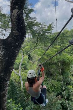 a woman is zipping through the trees on a rope