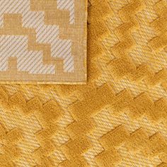 a close up view of the back of a yellow sweater with white squares on it